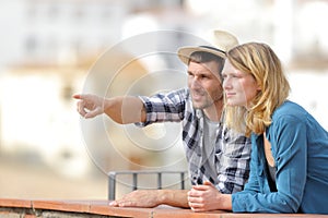 Couple of tourists sightseeing pointing at horizon