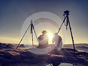 Couple tourists take pictures to background of hills and sky