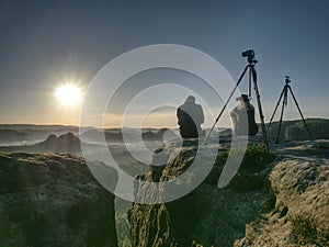 Couple tourists take pictures to background of hills and sky