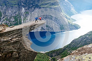 Couple of tourists on Trolltunga in Norway