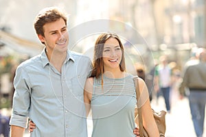 Couple of tourists walking in a city street photo
