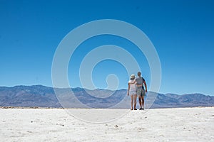 Couple tourists walking on great salt lake desert, death valley