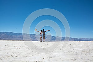 Couple tourists walking on great salt lake desert, death valley