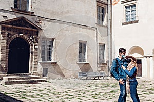 Couple of tourists walking in Olesko Castle yard wearing masks. Travelling during coronavirus covid pandemic in Ukraine.