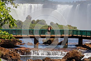 Couple of tourists watching Iguazu Falls, Misiones, Argentina