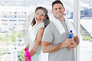 Couple with towels and water bottles at gym