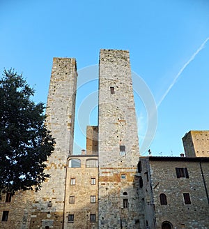A couple of towers of San Gimignano in Italy against deep blue sky, lit by pale setting sun