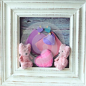 Couple of toys Teddy bears in a frame decorated with hearts