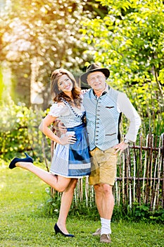 Couple in traditional bavarian clothes standing in the garden