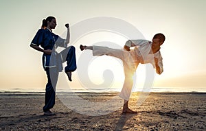 Couple training in martial arts on the beach