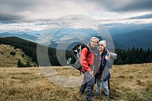 Couple traveler with backpacks in the alps, hikers in the mountains, happy active lifestyle, hiking man and woman