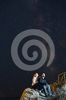 Couple traveler enjoying watched the star and milky way galaxy over the sky on top of the mountain. Night landscape with beautiful