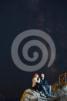 Couple traveler enjoying watched the star and milky way galaxy over the sky on top of the mountain. Night landscape with beautiful