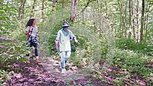 Couple travelers discussing their route walking down mountain forest.