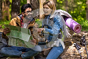 A couple of travelers scrutinizing the map and searching for a new route