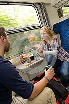 Couple traveling by train eating sandwiches hungry