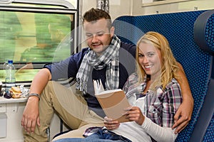 Couple traveling by train woman reading smiling