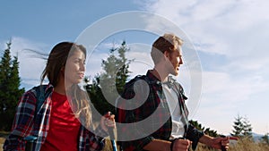 Couple trekking mountains at vacation. Man and woman talking during hiking