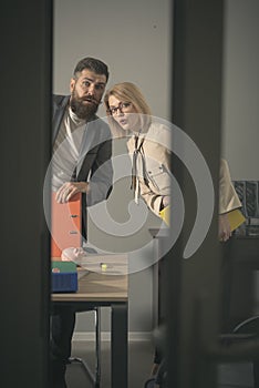 Couple with troubled faces look out modern office. Couple of colleagues at business meeting in office with glass walls