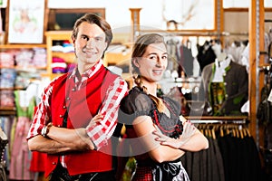 Couple is trying Dirndl or Lederhosen in a shop photo