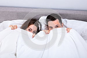 Couple Trying To Hide In Blanket