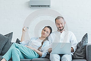 couple turning on air conditioner during the summer heat while