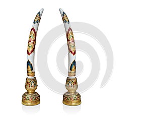 The couple tusks of an elephant is a hard cream-white substance on the gold wooden candlestick with golden Thai striped