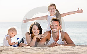 Couple with two children lying on beach