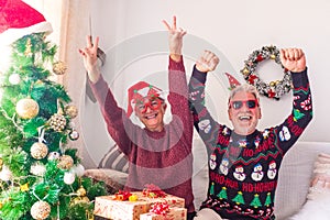 Couple of two crazy and funny seniors playing having fun together and celebrating doing a party at home the christmas day before