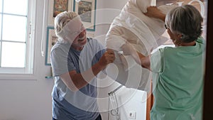 Couple of two happy seniors cooking together in the kitchen learning and following a video tutorial of cook in the laptop -