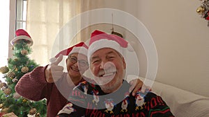 Couple of two old people smiling and looking at the camera - family selfie at home the christmas day together