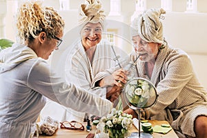Couple of two seniors enjoying a spa and massage traetment together with an assistance helping them - drinking cocktails and photo