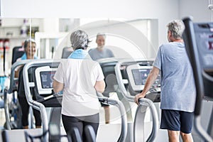 Couple of two seniors in relationship of friendship training together on the treadmill or tapirulan  - running at the gym and