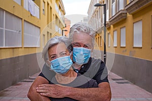 Couple of two seniors wearing medical mask to prevent coronavirus covid-19 or another type of virus - close up of faces in