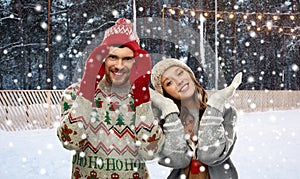 Couple in ugly sweaters on christmas ice rink