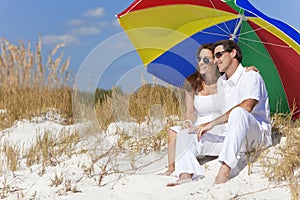 Couple Under Colorful Umbrella on Beach