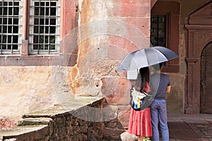 Couple under umbrella at tourist site castle