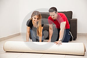 Couple unrolling a carpet photo