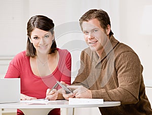 Couple using calculator to pay monthly bills