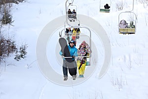 Couple using chairlift at mountain ski resort