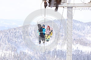 Couple using chairlift at mountain ski resort. Winter