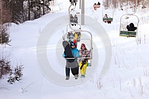 Couple using chairlift at mountain ski resort. Winter