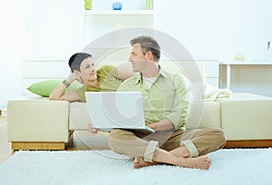 Couple using computer at home