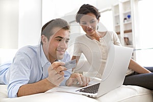 Couple using credit card to shop online