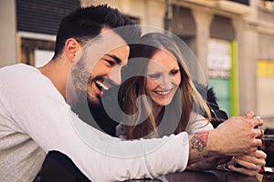 Couple using digital phone iphone and laughing in a terrace