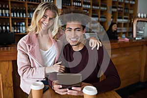 Couple using digital tablet in bar