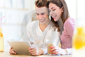 Couple using digital tablet at cafe