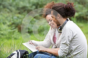 Couple Using Digital Tablet Whilst Hiking In Countryside
