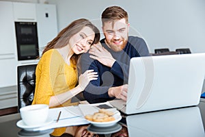 Couple using laptop computer at home