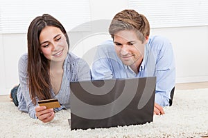 Couple using laptop and credit card to shop online